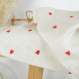 Tissu viscose lin brodé de petits coeurs rouges - fond sable. Idéal pour coudre des chemises ou des pantalons