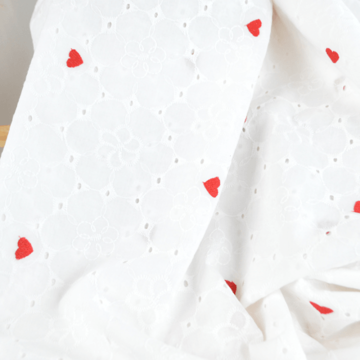 Tissu broderie anglaise brodé coeurs rouges fond blanc