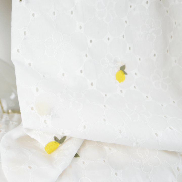 Tissu broderie anglaise brodé citrons jaunes fond blanc