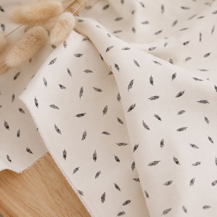Tissu popeline de coton motif plumes fond blanc