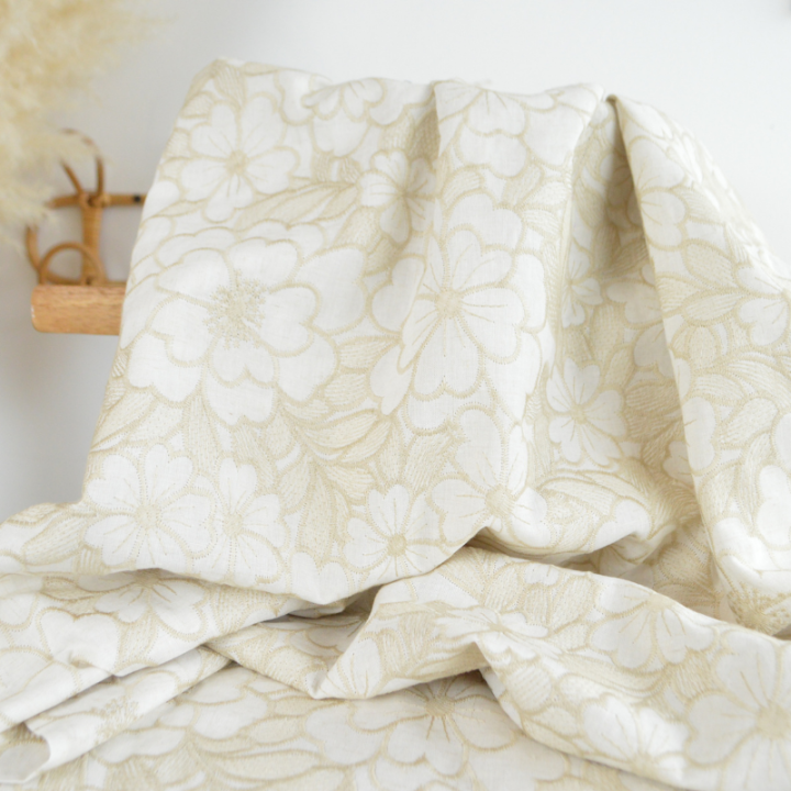 Tissu voile de coton brodé beige motif fleurs fond sable