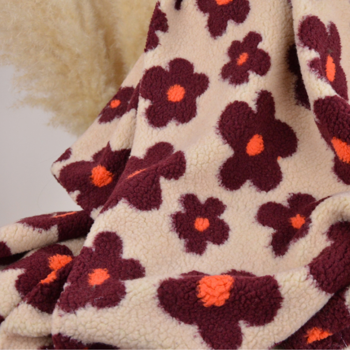 Tissu sherpa écru motif fleurs bordeaux et orange fond beige