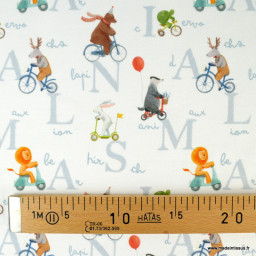 Tissu jersey motif animaux faisant du vélo fond blanc