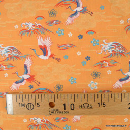 Tissu popeline motifs fleurs et Grues japonaises fond orange - Oeko tex