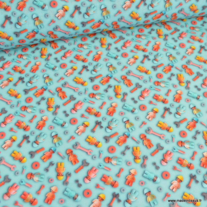 Tissu coton bleu clair avec motifs de mécaniciens façon Lego et outils, idéal pour couture enfant et créations ludiques