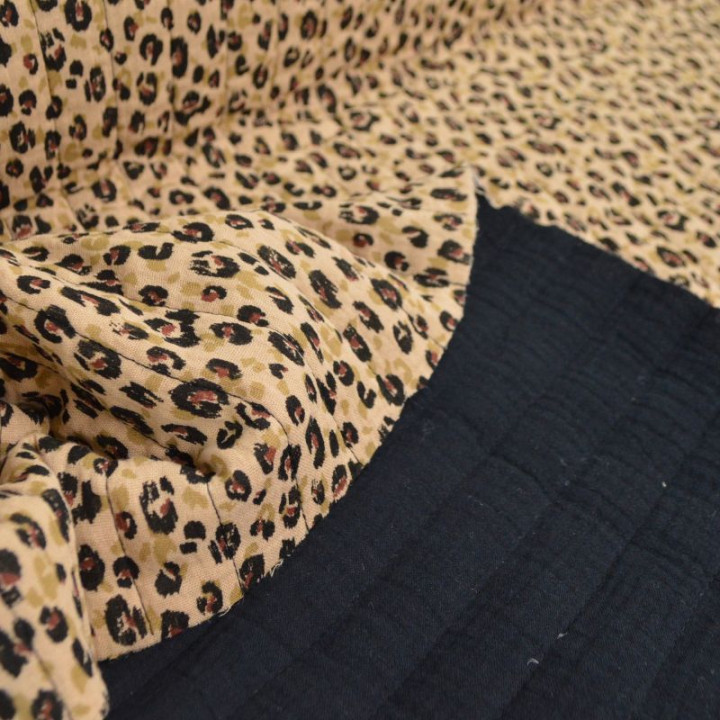 Double gaze de coton matelassée réversible, motif léopard beige et envers noir uni.