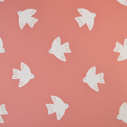 Tissu French Terry coton motif oiseaux blancs sur fond rose corail, envers bouclette